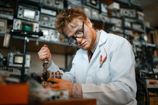 Strano scienziato lavora con il saldatore in laboratorio