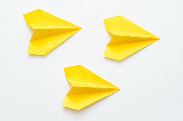 Strategia di direzione aziendale Tre aeroplani di carta gialli isolati su sfondo bianco Copia spazio