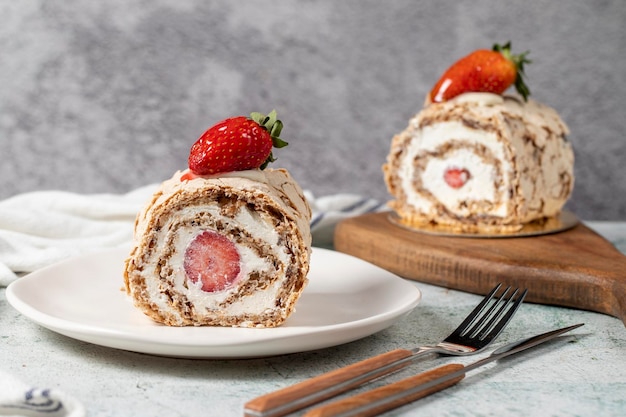 Strawberry Roll Cake Torta di legno con crema e fragole su uno sfondo di pietra da vicino