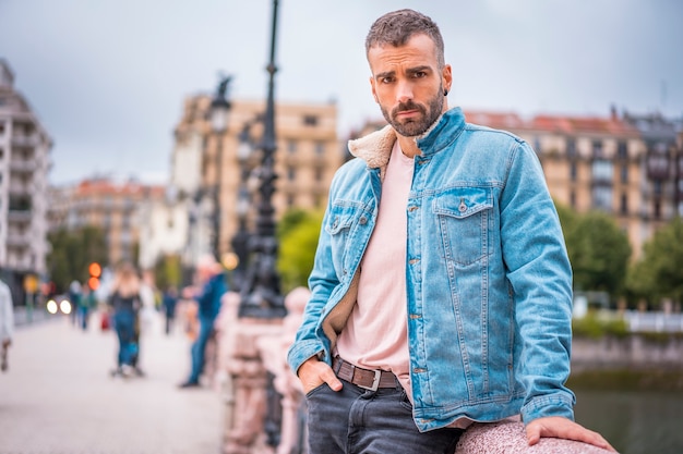 Street Style, un giovane con giacca di jeans che guarda a sinistra