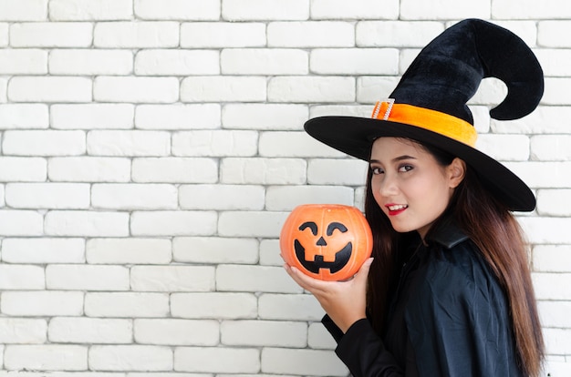 Strega di Halloween con una zucca magica