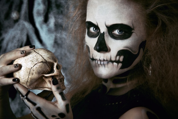 Strega di scheletro della ragazza che posa nelle ragnatele, Halloween