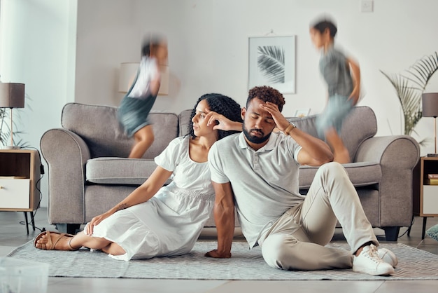 Stress stanco e genitori con bambini adhd che giocano sul divano rendendo la mamma triste esausta e frustrata con papà Mal di testa madre e padre sopraffatto con bambini rumorosi che saltano sul divano nella casa di famiglia