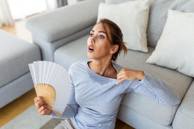 Stressato donna infastidita che usa la ventola sventolante soffre di surriscaldamento caldo estivo problema ormonale salute donna sudore sentirsi a disagio caldo in estate problema senza condizionatore d'aria