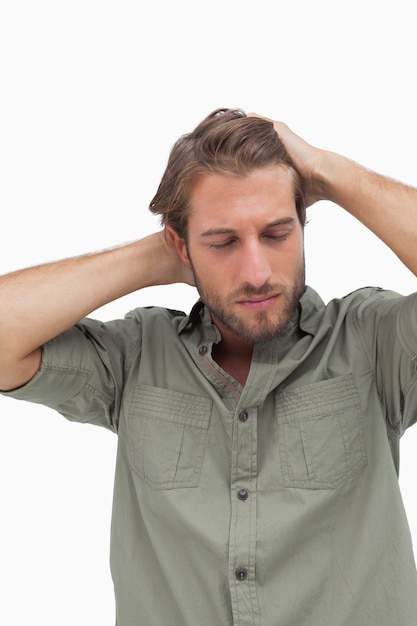 Stressato uomo guardando verso il basso con le mani sulla testa