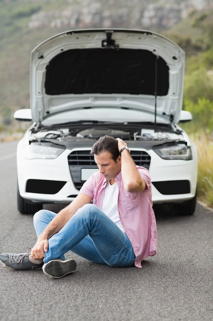 Stressato uomo seduto dopo un guasto alla macchina