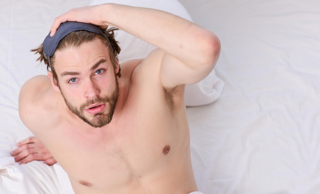 Stretching dopo il risveglio al mattino Bell'uomo che usa l'orologio a letto dopo essersi svegliato al mattino