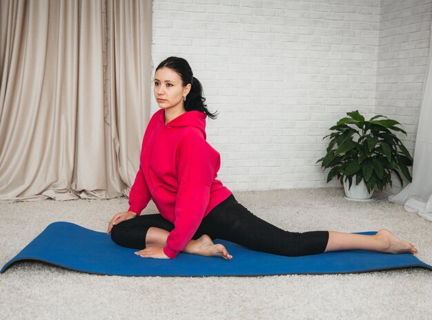 Stretching ginnico per tutto il corpo. Stile di vita e alimentazione sana. la donna è impegnata nello yoga. Abbigliamento comodo per l'aerobica.