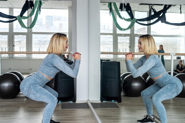 Stretching sull'allenamento di una giovane donna in palestra per migliorare il suo corpo