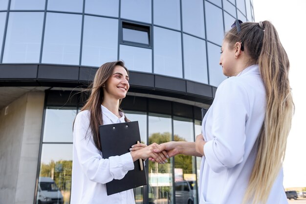 Stretta di mano dei partner commerciali prima dell'edificio per uffici