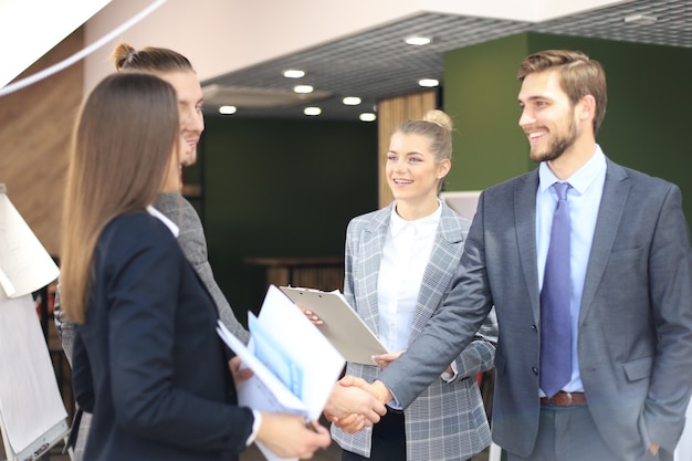 Stretta di mano dei partner commerciali su oggetti aziendali sul posto di lavoro.