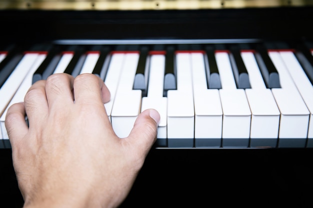 Stretta di mano persone uomo musicista suonare la tastiera del pianoforte con i tasti di messa a fuoco selettiva.