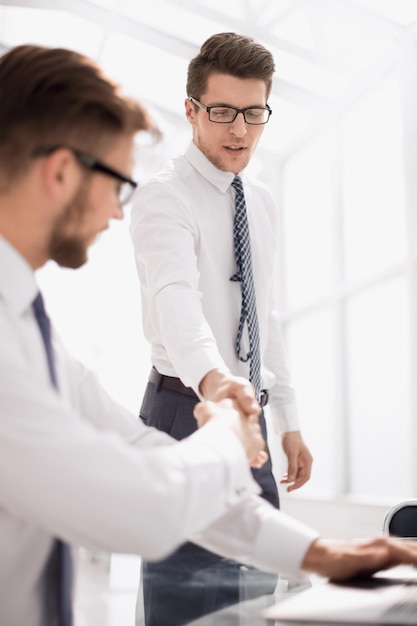 Stretta di mano stretta ai dipendenti sul posto di lavoroil concetto di professionalità