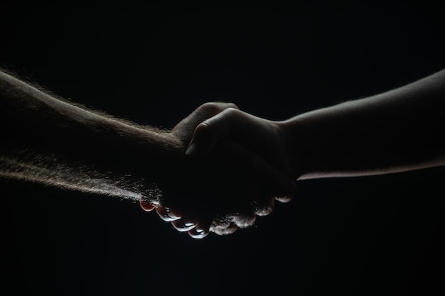 Stretta di mano tra l'accordo tra i due partner Salvataggio delle mani maschili Stretta di mano amichevole amici che salutano l'amicizia Salvataggio che aiuta gesto o mani Aiutando la mano