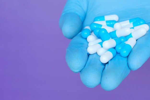 stretta di mano uomo in guanti protettivi in possesso di capsule
