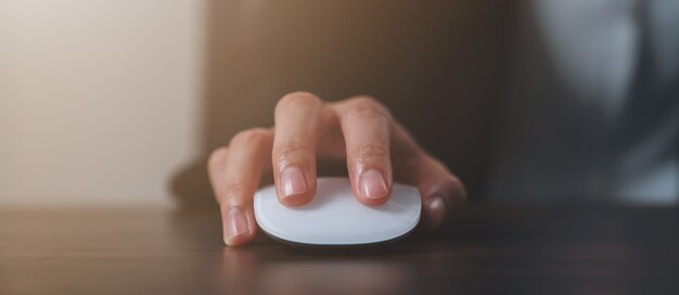 Stretta di mano utilizzando il mouse bianco e facendo clic sul tavolo dell'ufficio.