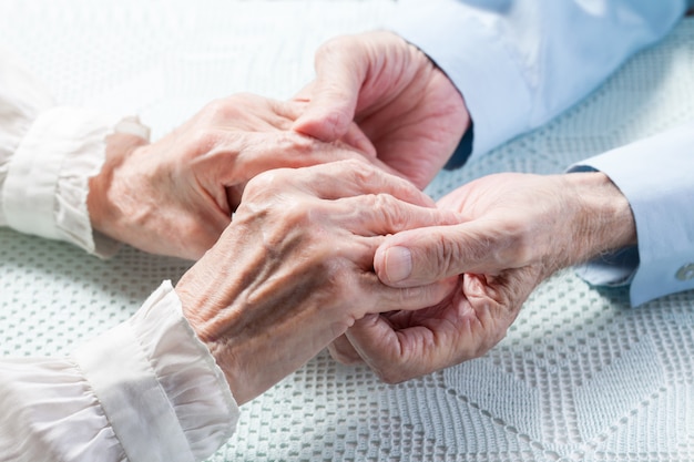 stretta di persone anziane che tengono le mani