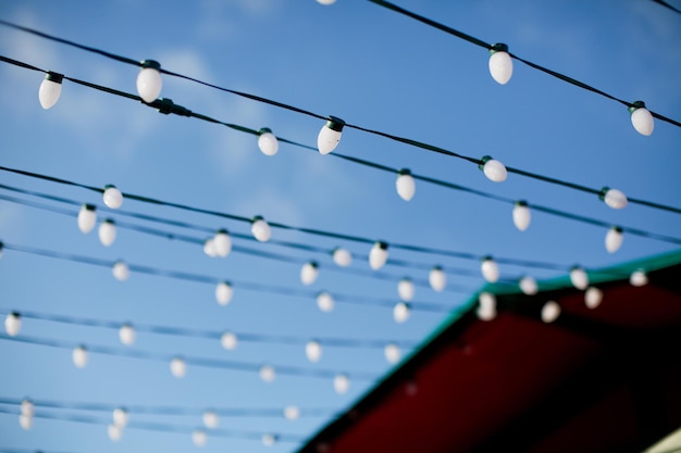 Stringa con luci bianche e cielo blu Ghirlanda di luci accoglienti per l'atmosfera natalizia all'aperto