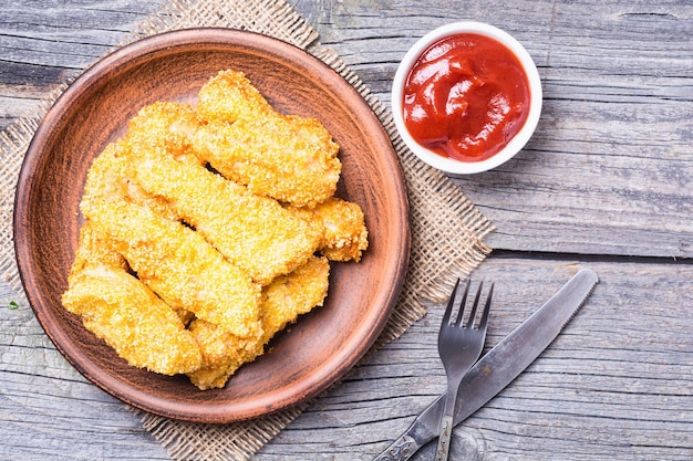 strisce di pollo su fondo di legno rustico