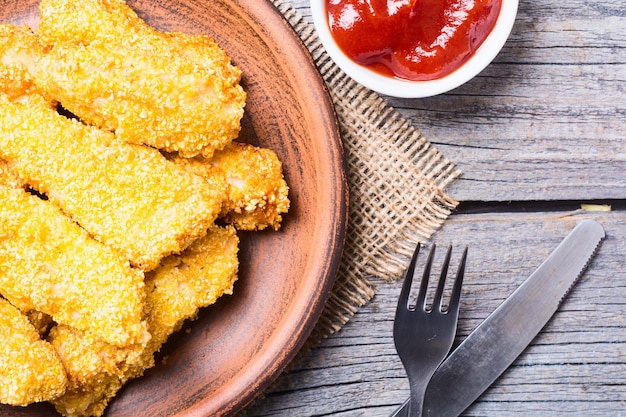 strisce di pollo su fondo di legno rustico