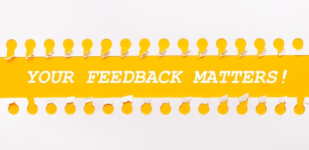 Striscia di carta strappata su sfondo giallo con testo IL TUO FEEDBACK È IMPORTANTE