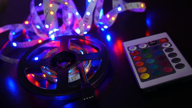 Striscia LED nei colori viola e un pannello di controllo per la commutazione dei colori. Sfondo scuro