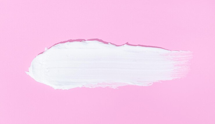 Foto striscio di crema bianca per viso o corpo isolato su sfondo rosa
