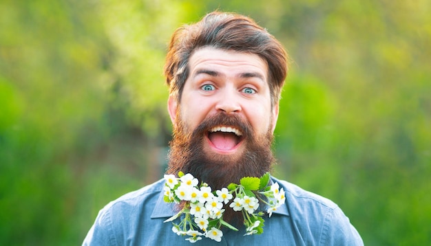 Striscione primaverile dell'uomo fiore all'aperto barba testa divertente ritratto di un uomo barbuto che guarda il camer