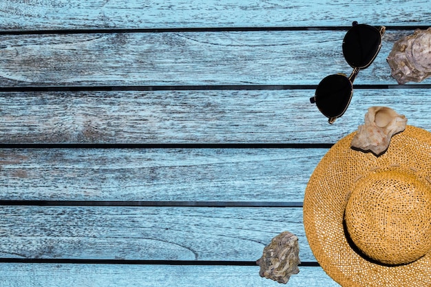 Striscioni per pubblicità cappello occhiali conchiglie su uno sfondo di legno di colore blu