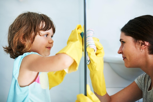 Strofina finché non brilla Inquadratura di una madre e una figlia che fanno le faccende domestiche insieme