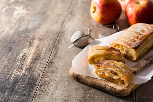 Strudel alle mele casalingo tradizionale sullo spazio di legno della copia della tavola