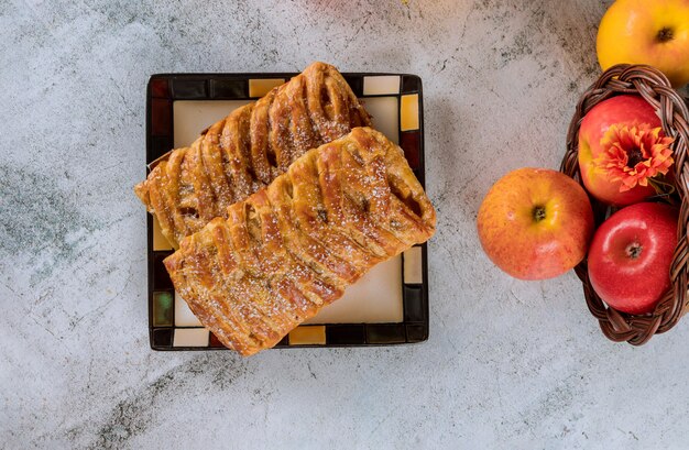 Strudel di mele su piastra quadrata con mele.