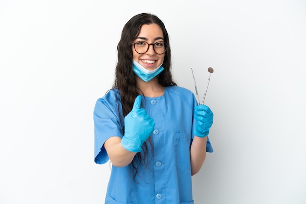 Strumenti della tenuta del dentista della giovane donna isolati