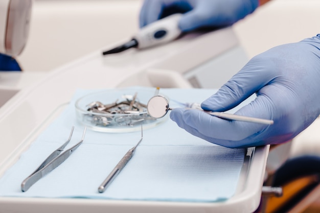 Strumenti dentali per testare la cavità orale e la mano del medico da vicino