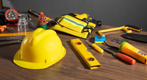 Strumenti di lavoro con casco su sfondo di legno