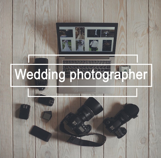Strumenti di lavoro fotografo matrimonio laici piatta. Vista dall'alto su macchine fotografiche con attrezzatura, smartphone, pacco di soldi e laptop con foto di matrimonio