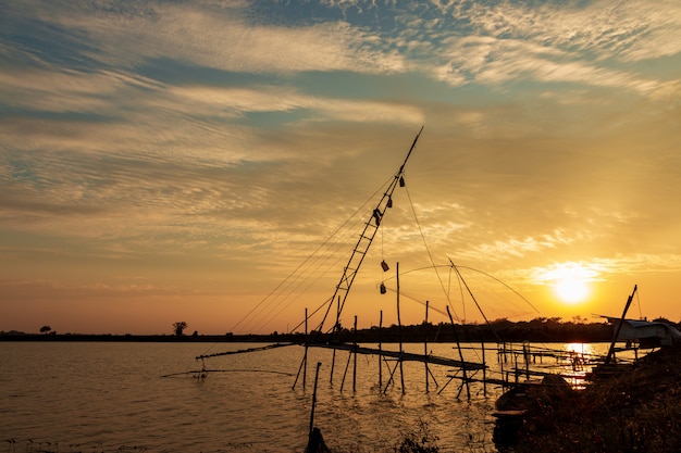 Strumenti di pesca del pescatore nel lago al cielo al tramonto.