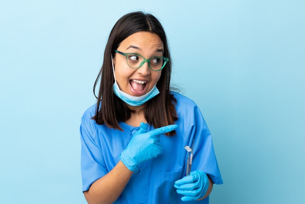 Strumenti di tenuta della giovane donna del dentista della corsa mista del brunette