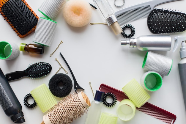 strumenti per capelli, bellezza e concetto di parrucchiere - spazzole, spray per lo styling, arricciacapelli e spilli su sfondo bianco