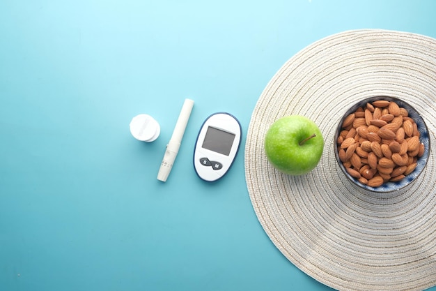Strumenti per la misurazione del diabete mandorla e mela sul tavolo