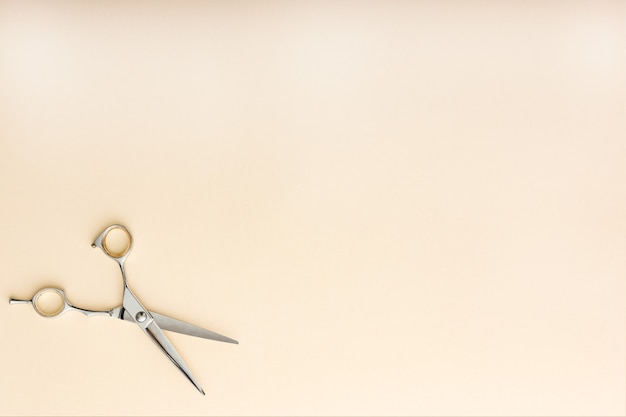 Strumenti per parrucchieri. Forbici da parrucchiere su sfondo di colore beige con copia spazio per il testo. Servizio di parrucchiere. Servizio di salone di bellezza