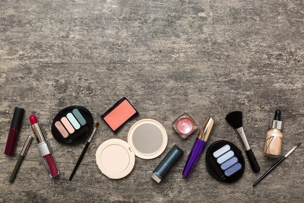 Strumenti professionali per il trucco Vista dall'alto Disposizione piatta Cosmetici decorativi di bellezza Set di pennelli per trucco e tavolozza di ombretti colorati sullo sfondo del tavolo Stile minimalista