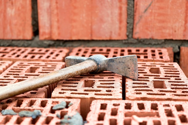 Strumento di costruzione per la posa di mattoni e blocchi Strumenti del muratore martello spatola cazzuola guanti Utensili manuali sullo sfondo della muratura