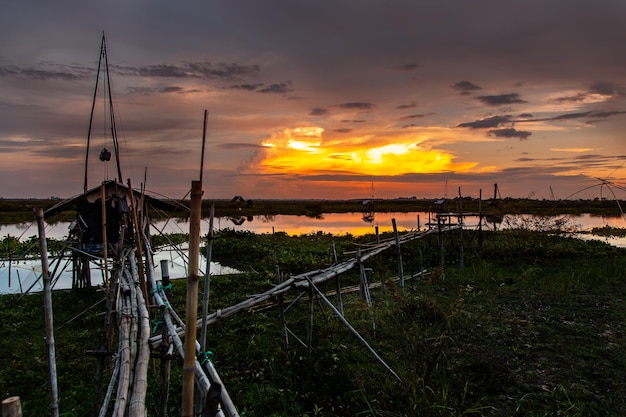 Strumento di pesca tradizionale o trappola per pesci di bambù sulla silhouette del paesaggio della luce del tramonto