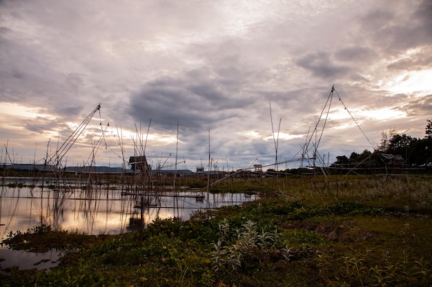 Strumento di pesca tradizionale o trappola per pesci di bambù sulla silhouette del paesaggio della luce del tramonto