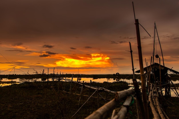 Strumento di pesca tradizionale o trappola per pesci di bambù sulla silhouette del paesaggio della luce del tramonto