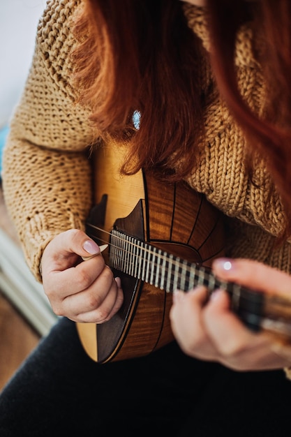 Strumento musicale popolare Domra in mano femminile mani femminili con corde in legno naturale musicale fatto a mano