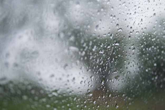 Struttura astratta sfocato sfondo di goccia di pioggia sulla finestra nel fuoco selettivo stagione delle piogge