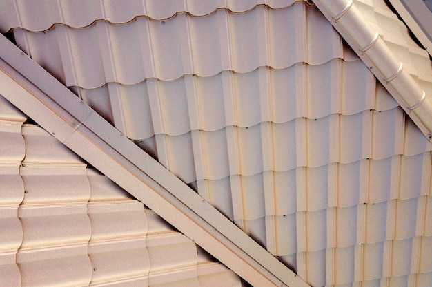 Struttura del tetto della casa ricoperta da lastre di tegole metalliche marroni.