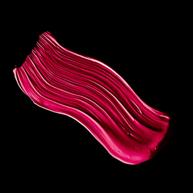 Struttura del tratto di pennello rossetto rosa isolata su sfondo nero